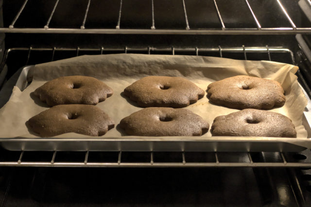 Six cookies on a sheet pan baking in an oven