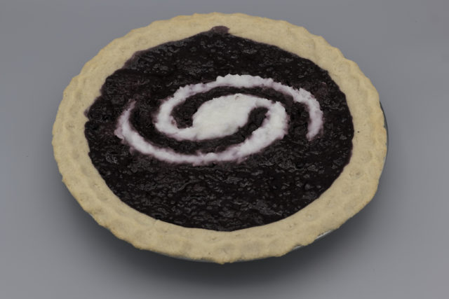 Pie with a light crust, dark filling, and a white spiral galaxy inset in the filling