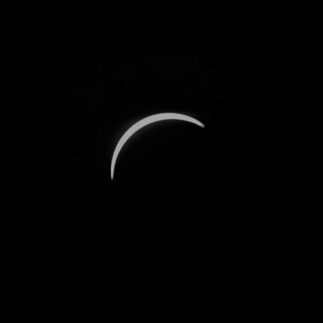 A close-up view of a sliver of the sun visible just before it is completely covered during the eclipse